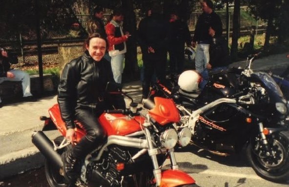 Ryan Cunningham sitting on an orange motorcycle